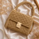 Beige gehäkelte Canvas-Handtasche mit Klappe und Goldkette – moderne Tasche häkeln Anleitung zum Selbermachen.